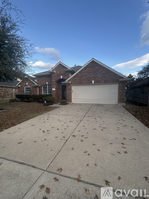 A house with a driveway and fallen leaves.