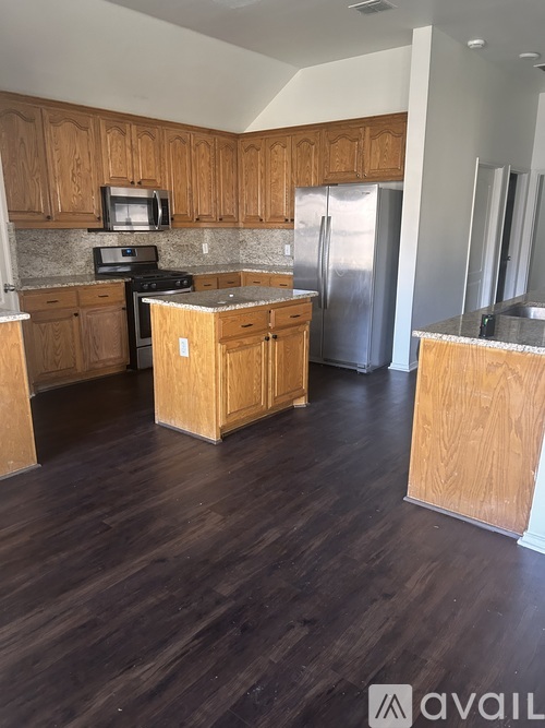 A kitchen with wooden cabinets and a refrigerator.