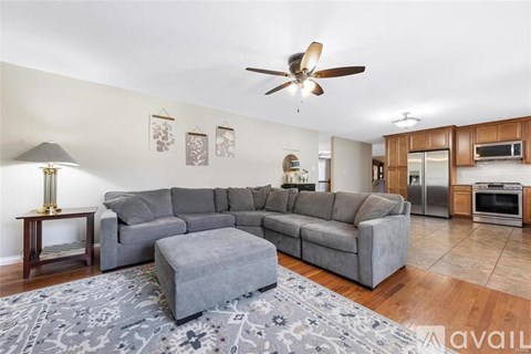 A living room with a grey sofa and a grey ottoman.