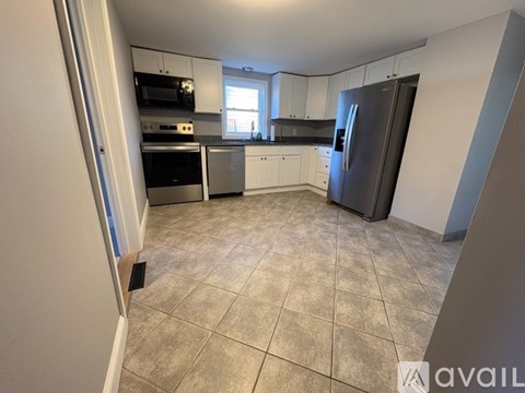 A kitchen with a black fridge, stove, and oven.