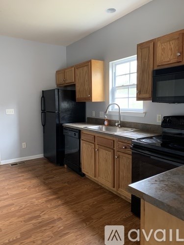 A kitchen with wooden cabinets and black appliances.