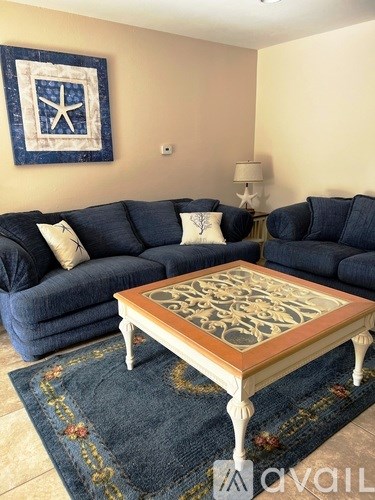 A living room with a blue couch and a coffee table.