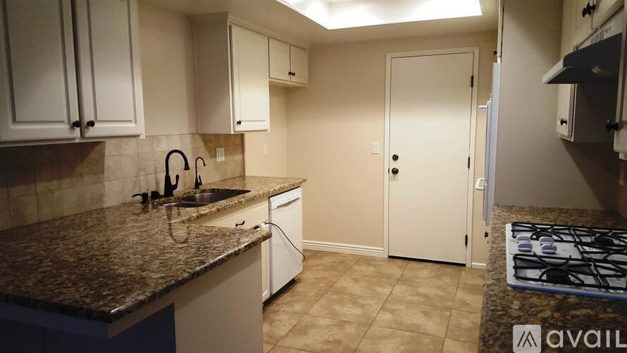 A kitchen with granite countertops and white cabinets.