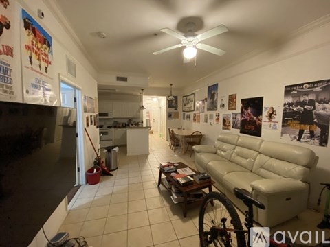 A living room with a white couch and a bicycle in the corner.