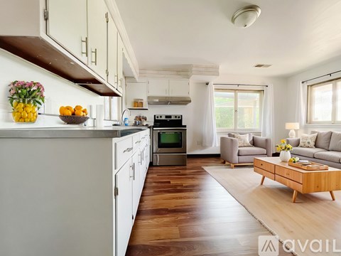 A kitchen with a white refrigerator and wooden floors.