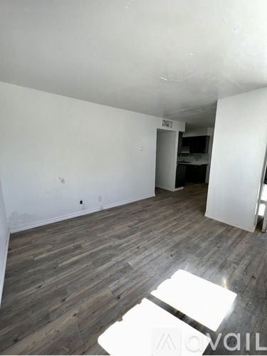 A room with wooden flooring and white walls.