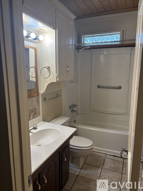 A white bathroom with a toilet, sink, and tub.