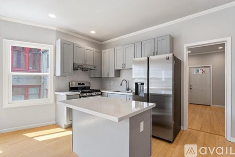 A kitchen with a large island and stainless steel appliances.