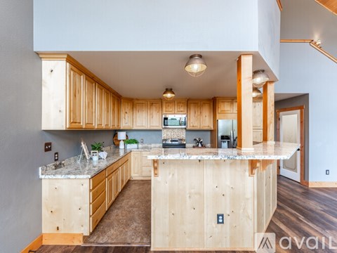 A kitchen with wooden cabinets and a marble countertop.