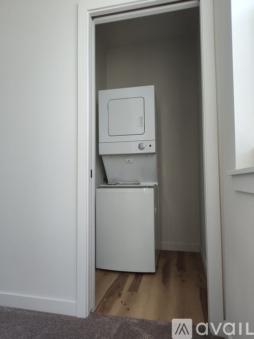 A white compact fridge is in a small space.
