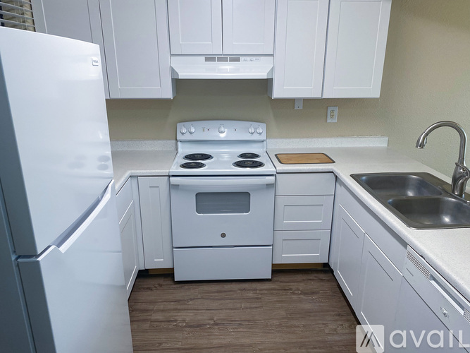 A well-lit kitchen area with a sink, cabinets, and a ceiling fan.