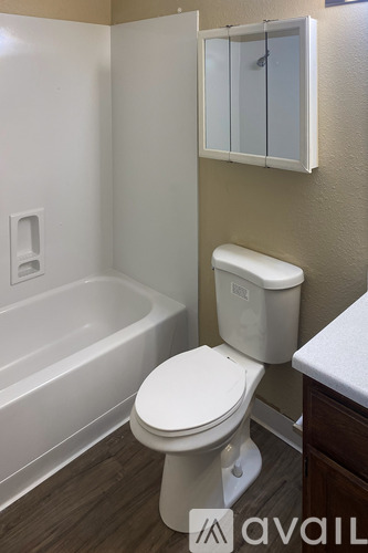 A white door is open to reveal a small bedroom with a bed and a closet.