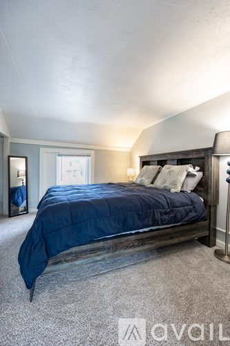 A bedroom with a bed covered in a blue comforter.