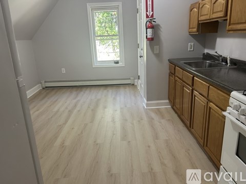 A kitchen with wooden cabinets and a white stove top oven.
