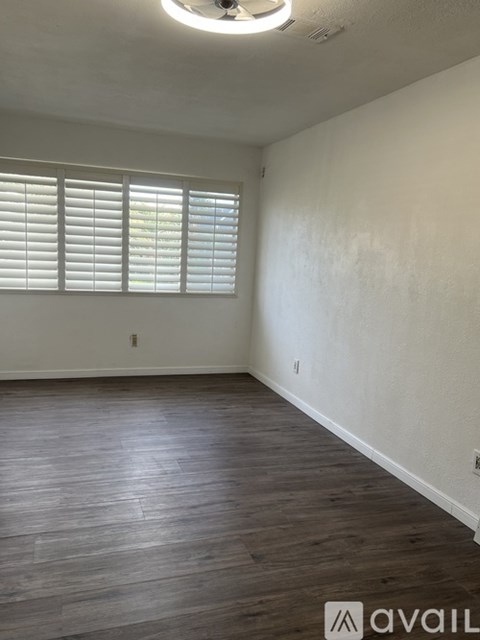 A room with wooden flooring and white walls.