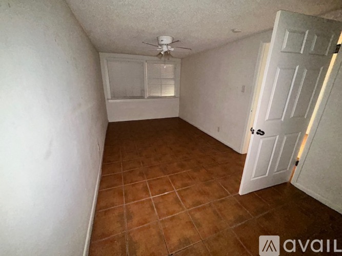 A room with a tiled floor and a window with blinds.