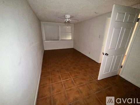 A room with a tiled floor and a window with blinds.