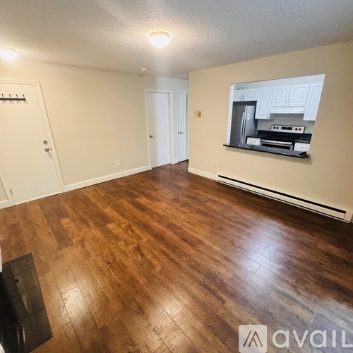 A room with wooden flooring and a wall-mounted TV.