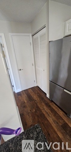 A spacious room with wood flooring and white walls.