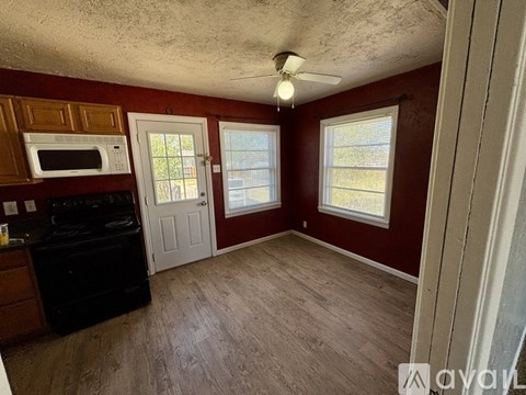 A kitchen with a black stove and a white door.