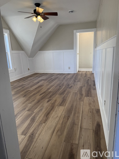 A room with wooden flooring and a ceiling fan.