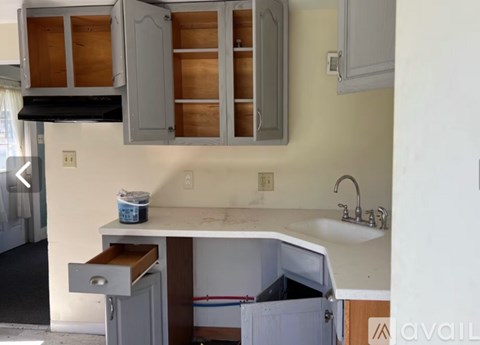 A kitchen with a white countertop and wooden cabinets.
