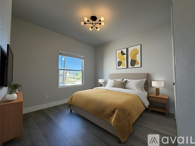 A bedroom with a large bed and a television on a stand.