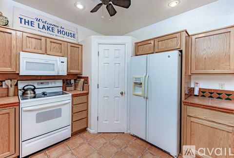A kitchen with wooden cabinets and a white refrigerator.