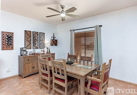 A dining room with a wooden table and chairs.