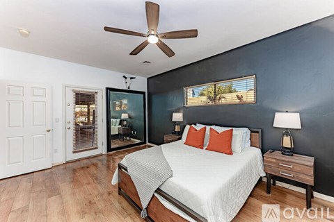 A bedroom with a bed, nightstands, and a ceiling fan.