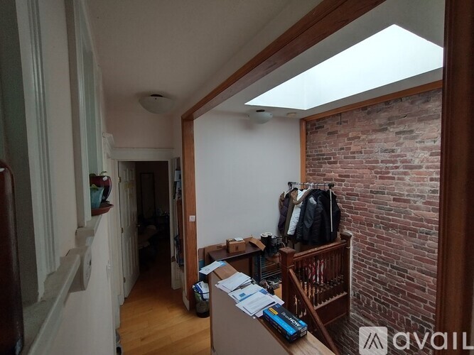 A room with a brick wall and a skylight.