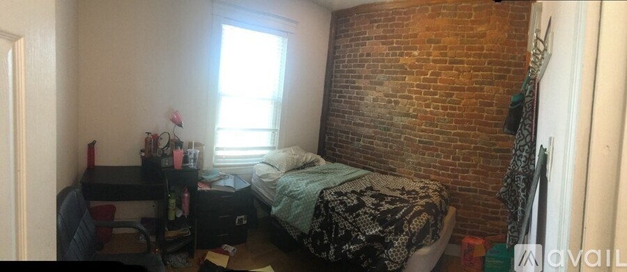 A bedroom with a bed, desk, and chair.
