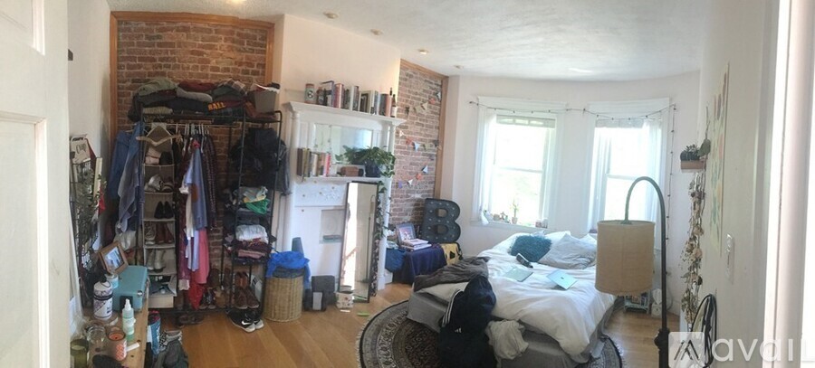 A bedroom with a bed, a wardrobe, and a fireplace.