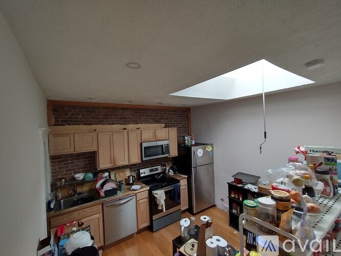 A kitchen with a brick wall and wooden cabinets.