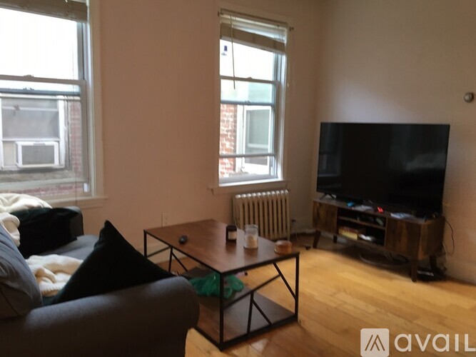 A living room with a couch, a coffee table, and a television.
