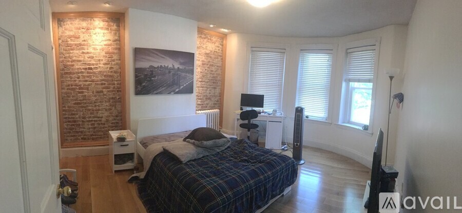A bedroom with a brick wall and a bed.