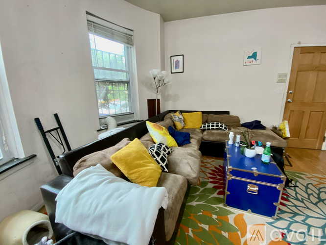 A living room with a couch, a coffee table, and a lamp.