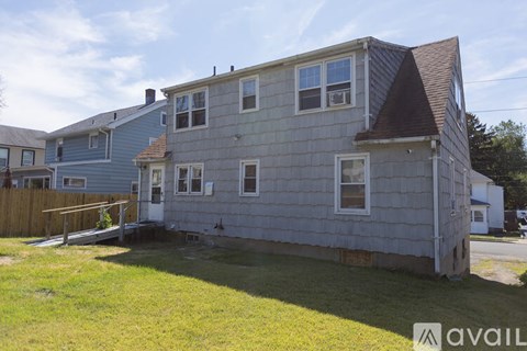 A house with a grey exterior and a brown roof is available for rent.