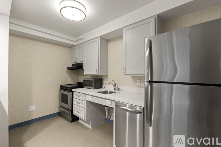 A kitchen with a stainless steel refrigerator and a white countertop.