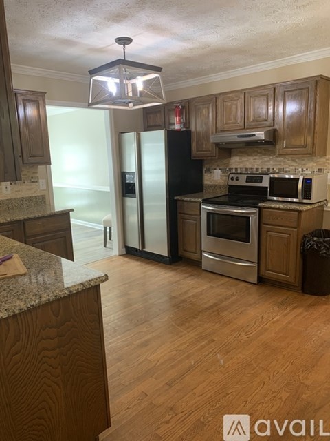 A kitchen with wooden cabinets and a granite countertop.