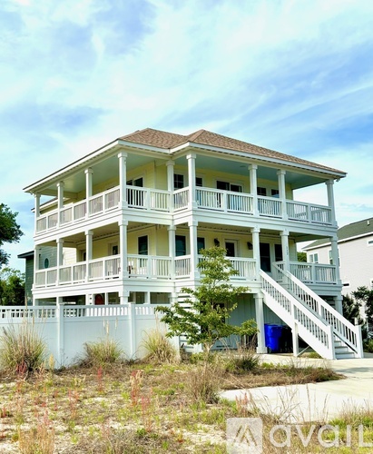 A white two story house with a balcony on the second floor.
