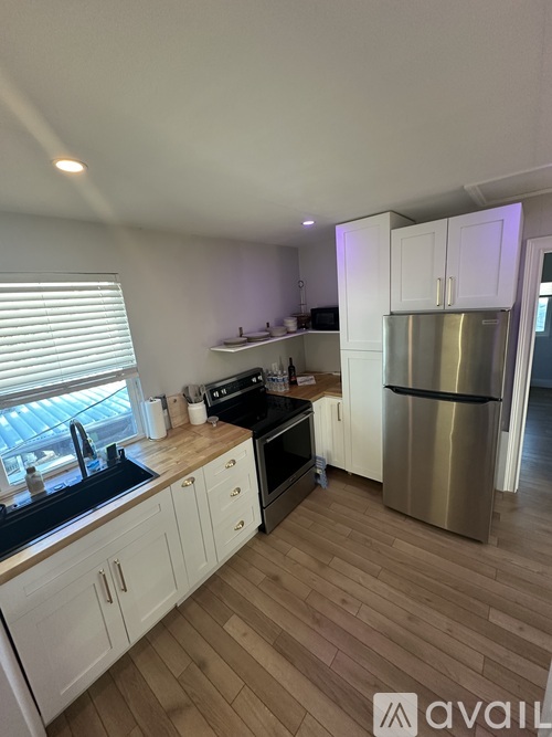 A kitchen with white cabinets and a wooden floor.