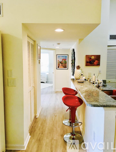 A kitchen with a red bar stool.