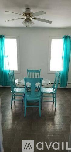 A dining room with a table and chairs.
