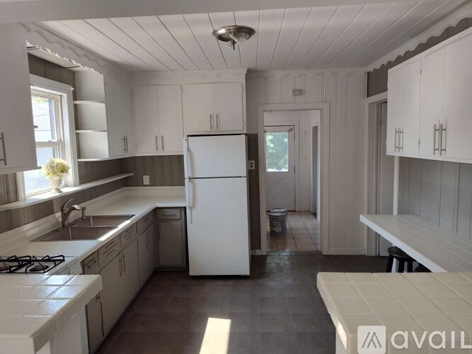 A kitchen with a white fridge and cabinets.