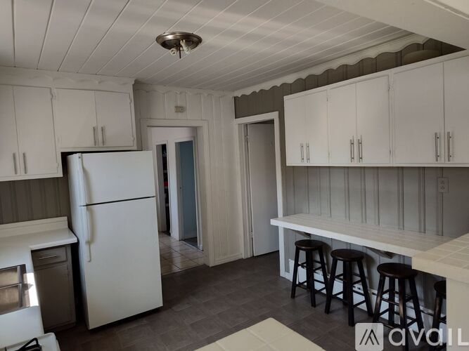 A kitchen with white cabinets and a white refrigerator.