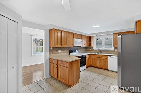 A kitchen with wooden cabinets and a refrigerator.