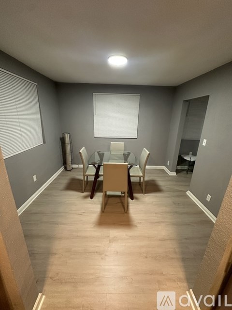 A room with wooden flooring and a window with blinds.