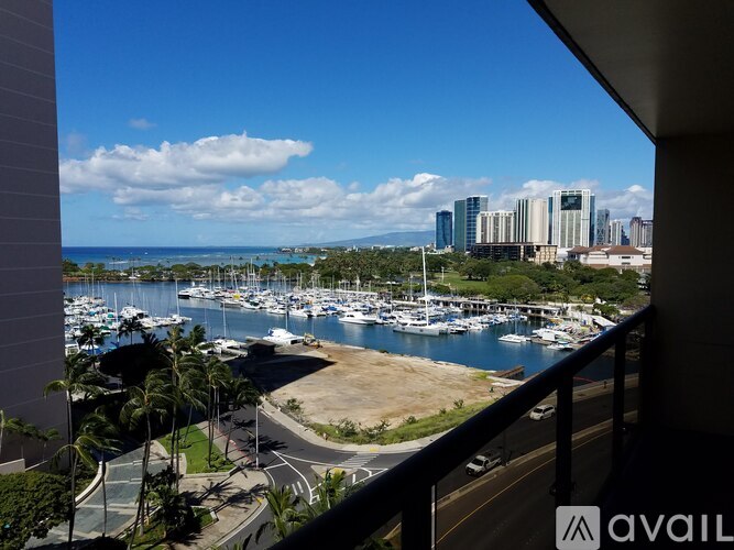 A view from a balcony overlooking a marina with boats and buildings in the distance.