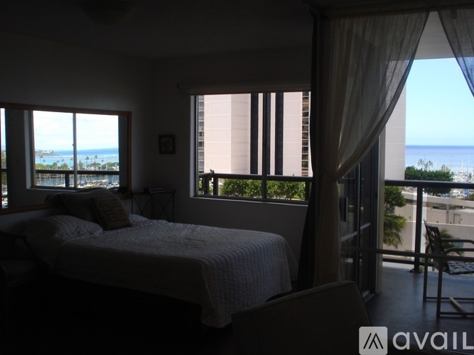 A bedroom with a large bed and a view of the ocean.